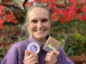 Customer Gower Lavender Smiling woman holding cosmetic products